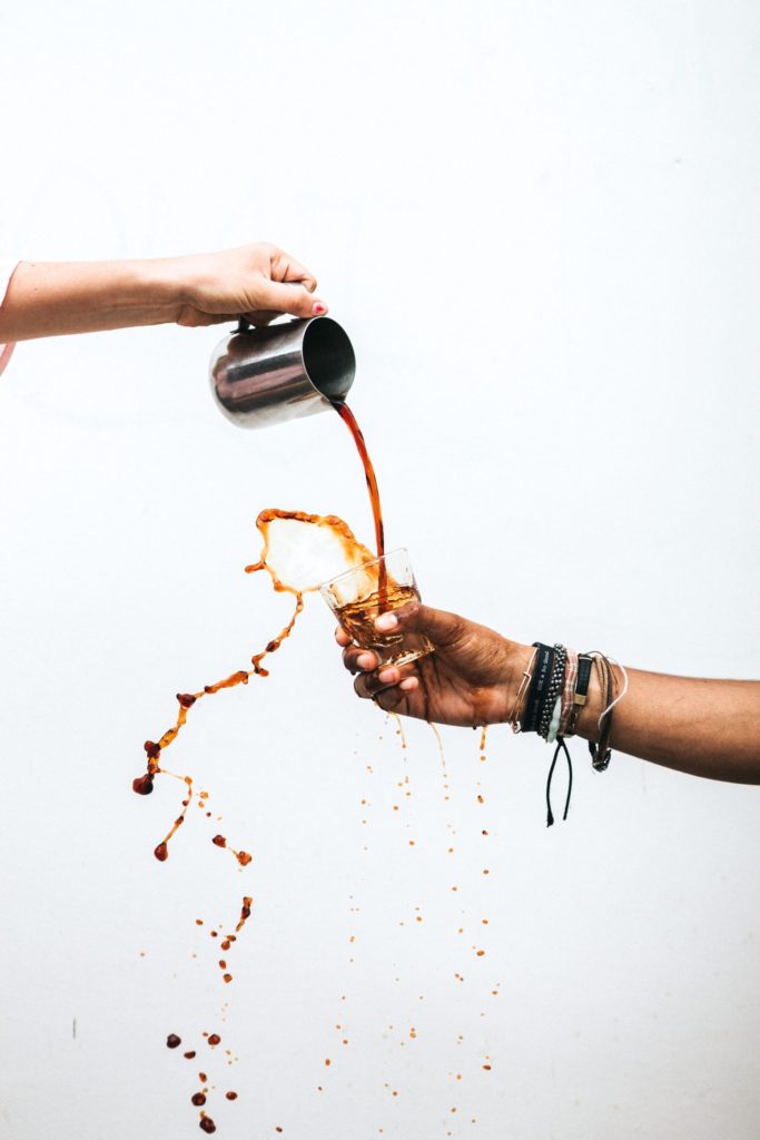 Future of Coffee 2.0 post, showing a hand pouring coffee in the air to a cup hold by another hand