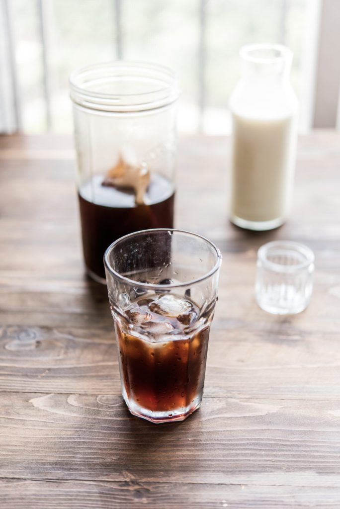 Instant coffee vs cold brew? Find out details in the article. Image showing glasses with coffee drinks on a wodden table