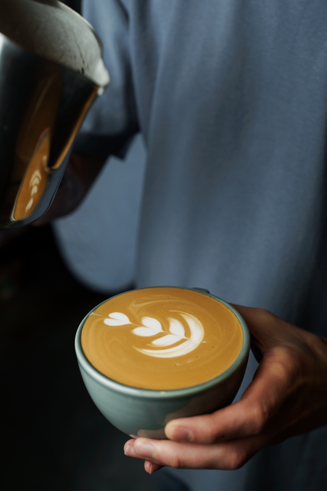 Image of an experienced barista making a Cappuccino, to illustrate the cappuccino origin from old days and to modern times